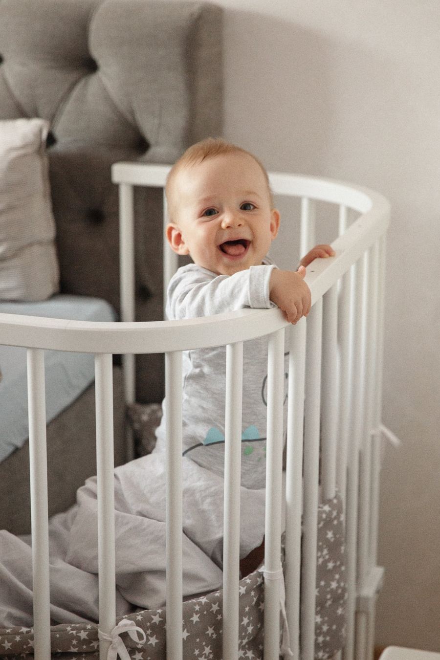 Lachendes Baby im Beistellbett, Babyfoto bei München