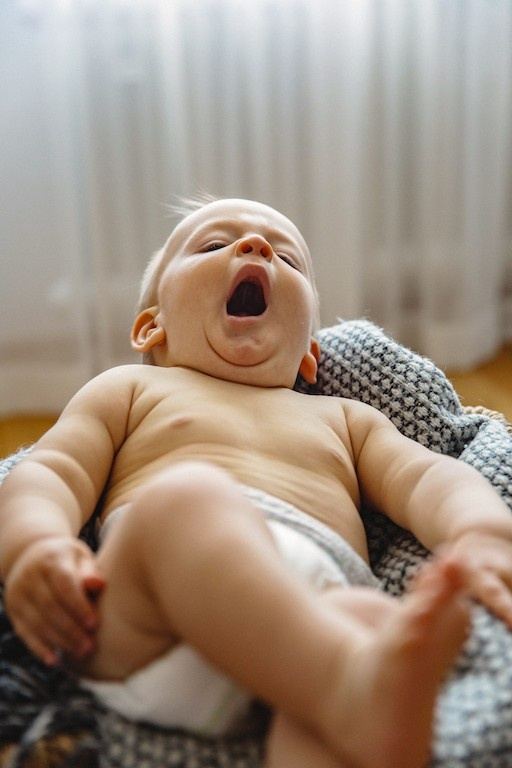 Lachendes Baby im Beistellbett, Babyfoto bei München