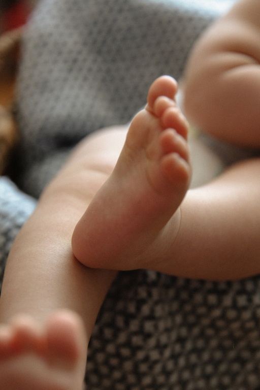 Lachendes Baby im Beistellbett, Babyfoto bei München