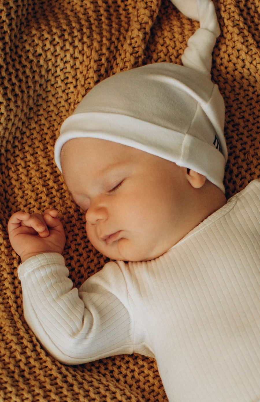 Baby auf Strickdecke in warmen Ockertönen