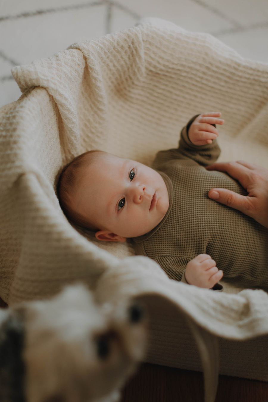 Baby auf Strickdecke in warmen Ockertönen