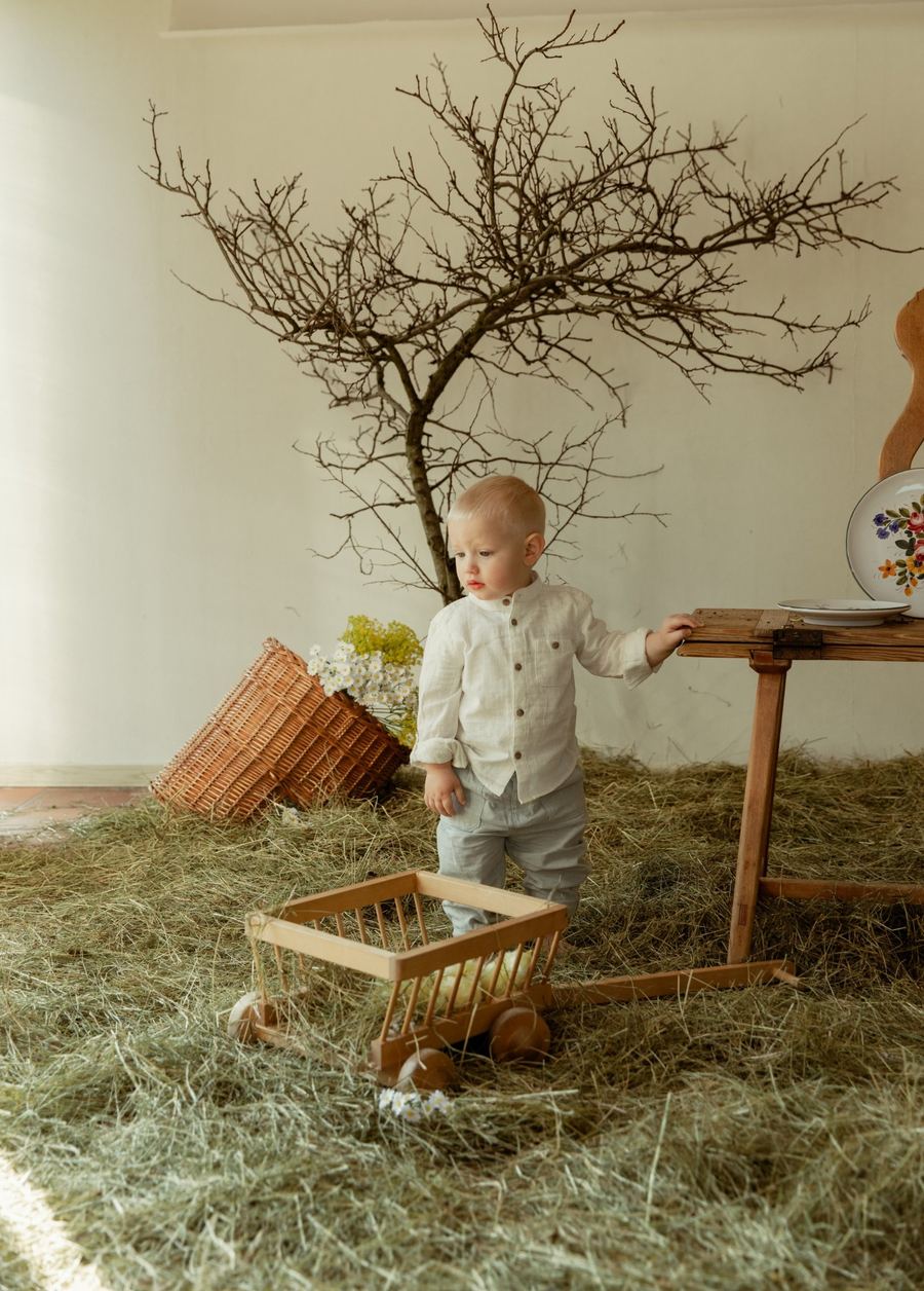 Osterfoto im Studio: Kleinkind mit Heu und Osterdeko