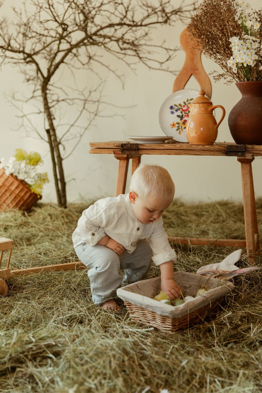 Osterfoto im Studio: Kleinkind mit Heu und Osterdeko