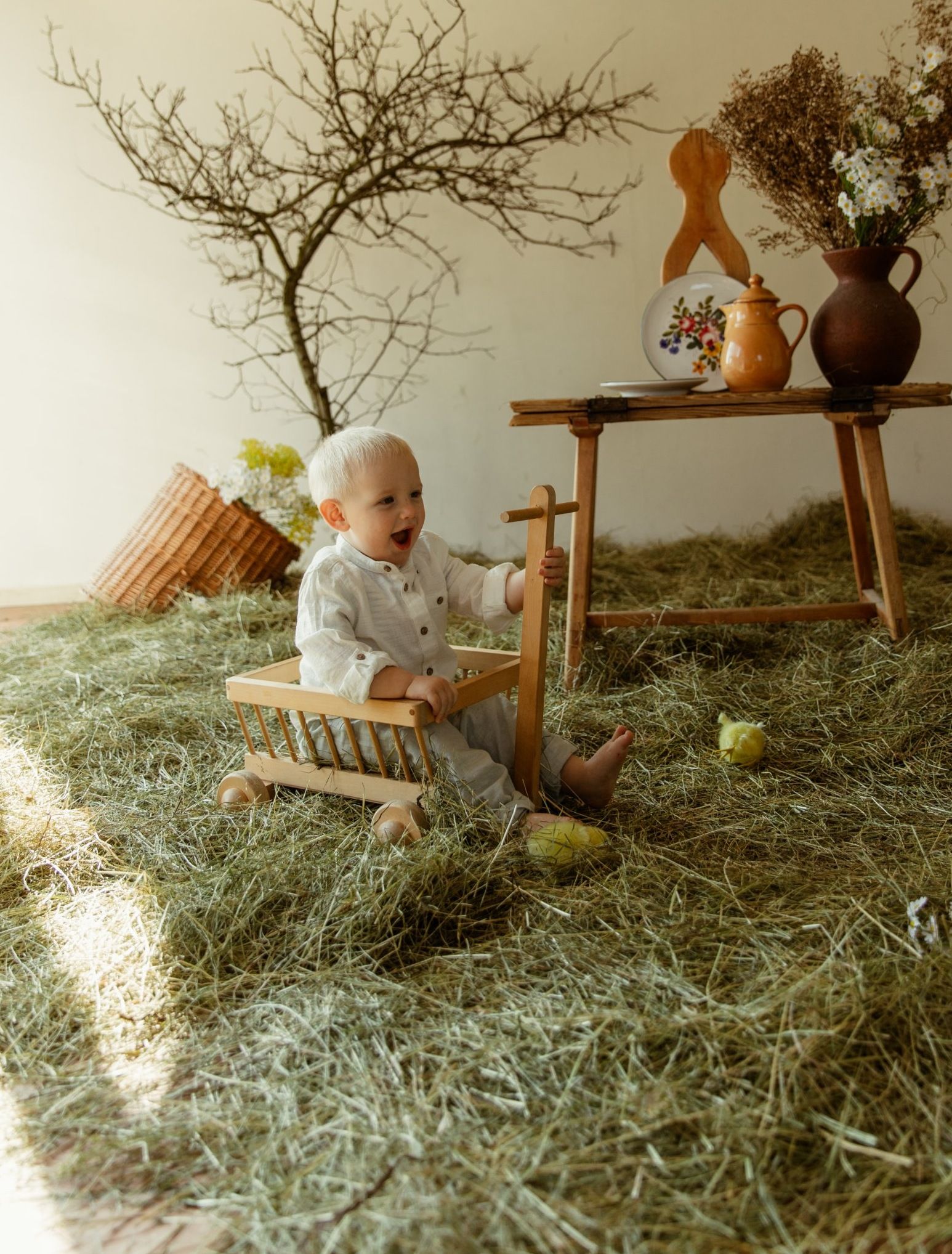 Osterfoto im Studio: Kleinkind mit Heu und Osterdeko