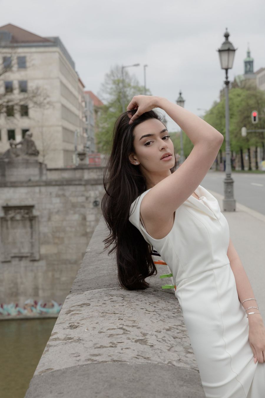 Fashion-Porträt in Weiß, Frau an einer Steinbrüstung